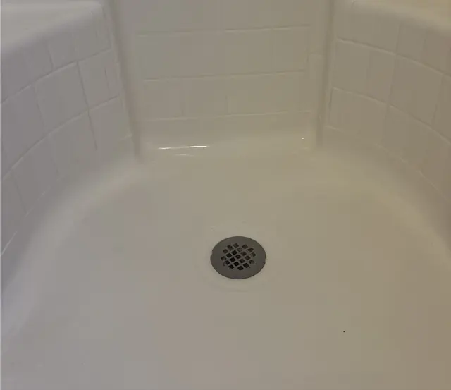 After: The same shower corner, white from wall to drain.